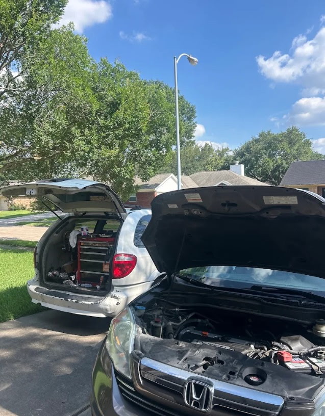 Mobile mechanic van servicing vehicles in the driveway
